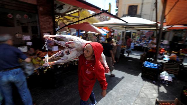 Un boucher dans le marché de Ballaro à Palerme. [Reuters - Guglielmo Mangiapane]