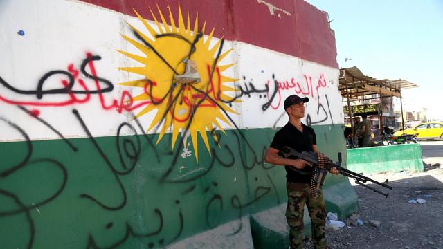 Un membre des forces irakiennes devant le drapeau du Kurdistan dans le sud de Kirkouk, le 17 octobre 2017. [EPA/Keystone - Bareq al-Samarrai]