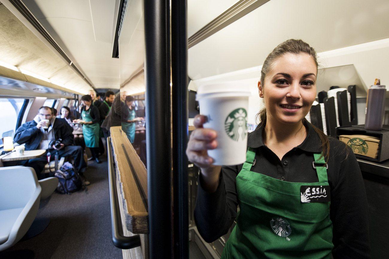Une employée dans un train équipée d'un wagon Starbucks. [Keystone - Ennio Leanza]