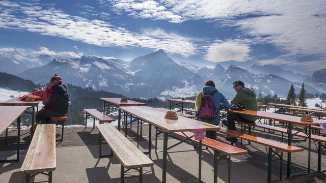 Des amateurs profitent de la vue et du beau temps dans buvette à Amden (SG), le 20 février 2017. [Walter Bieri]