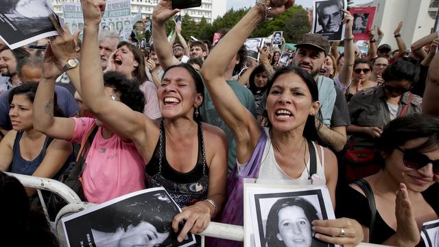 Des manifestants célébrent le verdict avec des images de personnes disparues lors de la dictature. [Keystone - Victor R. Caivano]