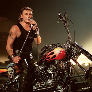 Le chanteur de rock et acteur français Johnny Hallyday se produit sur la scène du Palais Omnisport de Paris-Bercy, le 15 septembre 1992. [AFP - François-Xavier Marit]