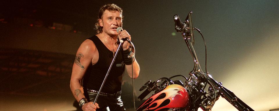 Le chanteur de rock et acteur français Johnny Hallyday se produit sur la scène du Palais Omnisport de Paris-Bercy, le 15 septembre 1992. [AFP - François-Xavier Marit]