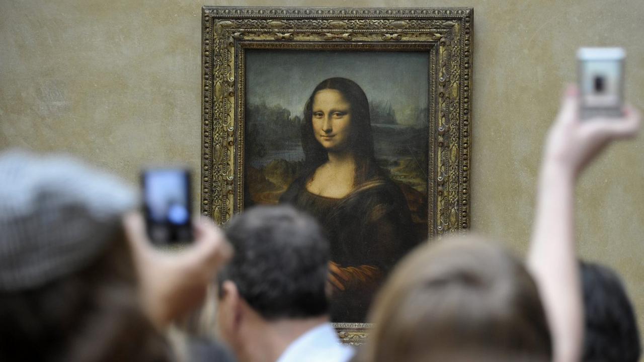Des visiteurs du Louvre à Paris devant la Joconde de Léonard de Vinci. [KEYSTONE - HORACIO VILLALOBO]