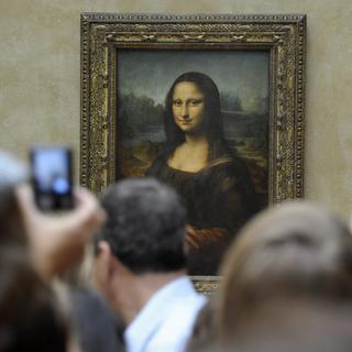 Des visiteurs du Louvre à Paris devant la Joconde de Léonard de Vinci. [KEYSTONE - HORACIO VILLALOBO]