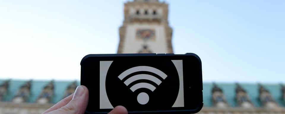 Un logo wifi sur un smartphone à Hambourg en 2014. [DANIEL REINHARDT / DPA]