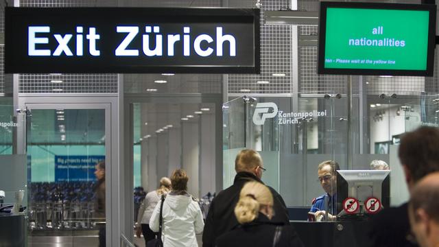 Des voyageurs au contrôle des passeports à l'aéroport de Zurich. [Keystone - Gaëtan Bally]