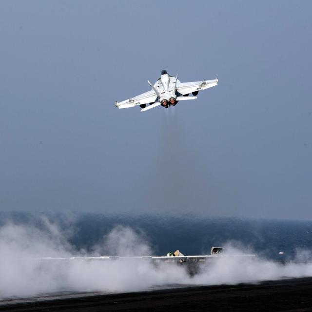 Un bombardier américain prend son envol depuis un porte-avion. [AFP - Petty Officer 3rd class Nathan T. BEARD]