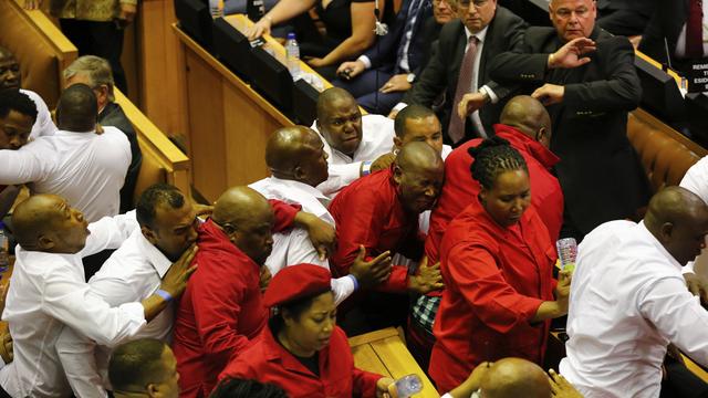 Scène de bagarre au Parlement sud-africain jeudi où des députés du parti de gauche des Combattants pour la liberté économique (EFF, en rouge) contestaient la légitimité du président Zuma. [Pool/AP/Keystone - Sumaya Hisham]