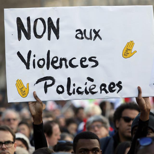 Un manifestant porte une pancarte dénonçant les violences policières, le 18 février 2017 à Paris [keystone - AP Photo/François Mori]