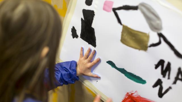 Une enfant fait de la peinture dans une garderie. [Keystone - Gaëtan Bally]