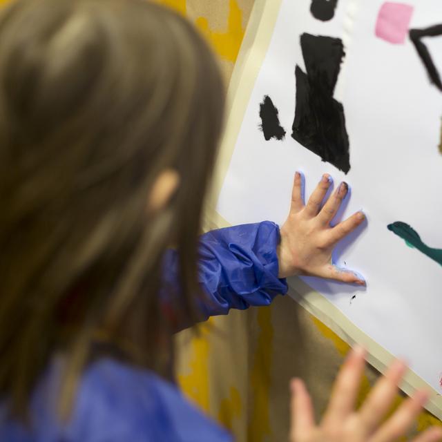 Une enfant fait de la peinture dans une garderie. [Keystone - Gaëtan Bally]