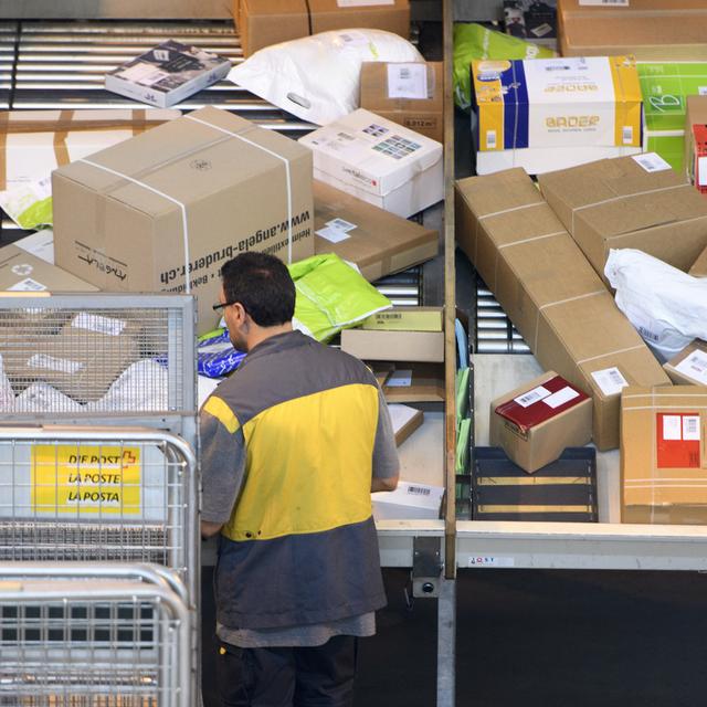 Avec les achats facilités par smartphone, La Poste doit jongler avec ses effectifs pour gérer les colis. [Keystone - Laurent Gilliéron]