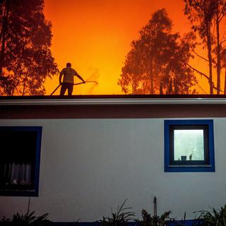 Un homme combat un incendie de forêt à Vieira de Leiria au Portugal. [EPA/Keystone - Ricardo Graca]