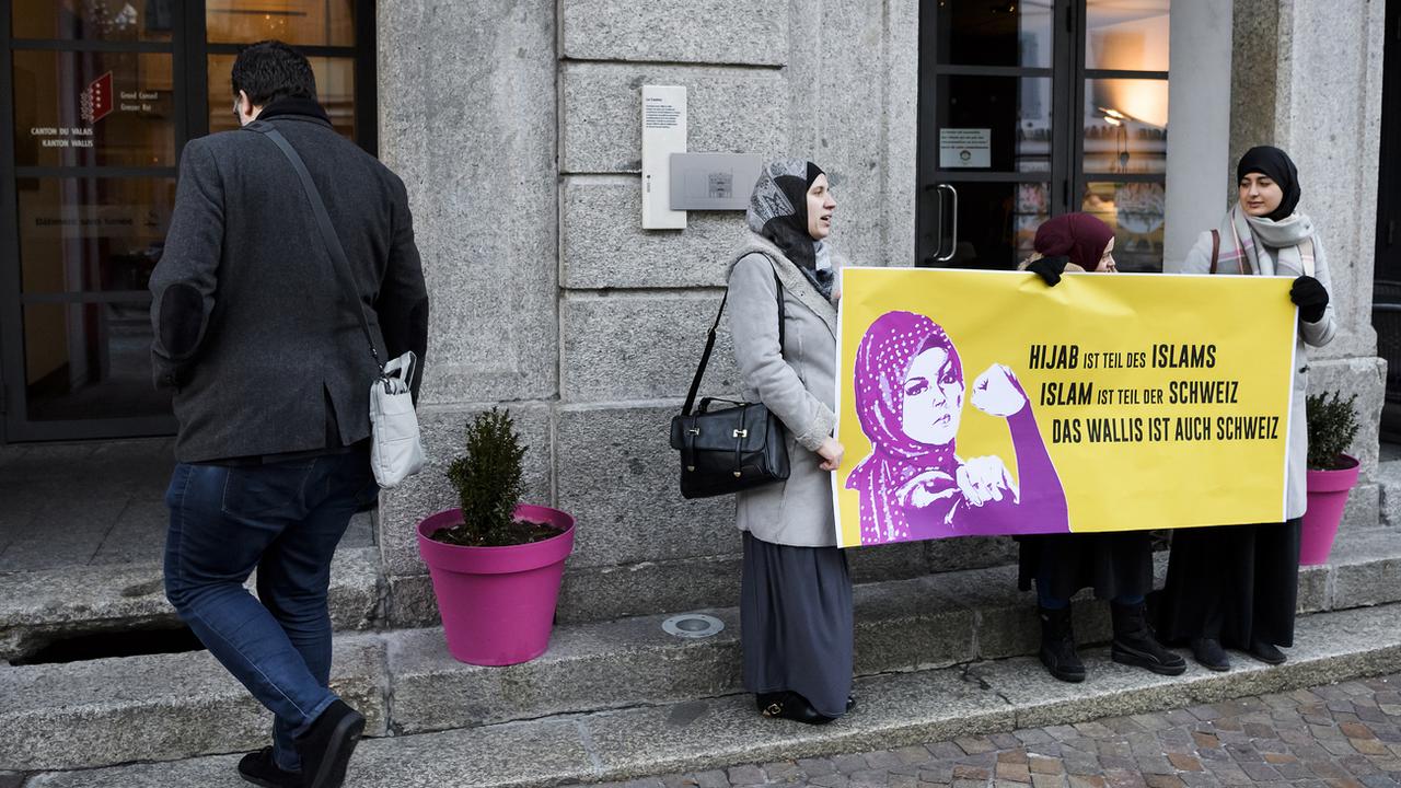 Des femmes du Conseil central islamique suisse manifestent devant le Grand Conseil valaisan contre l'initiative dite "tête nue". [Keystone - Jean-Christophe Bott]