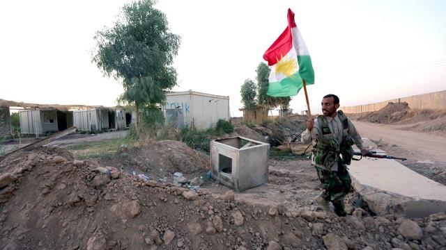 Une drapeau du Kurdistan brandi près de l'ancien QG des combattants peshmergas, dans la ville irakienne de Kirkouk, en octobre 2017. [Keystone - Murtaja Lateef]