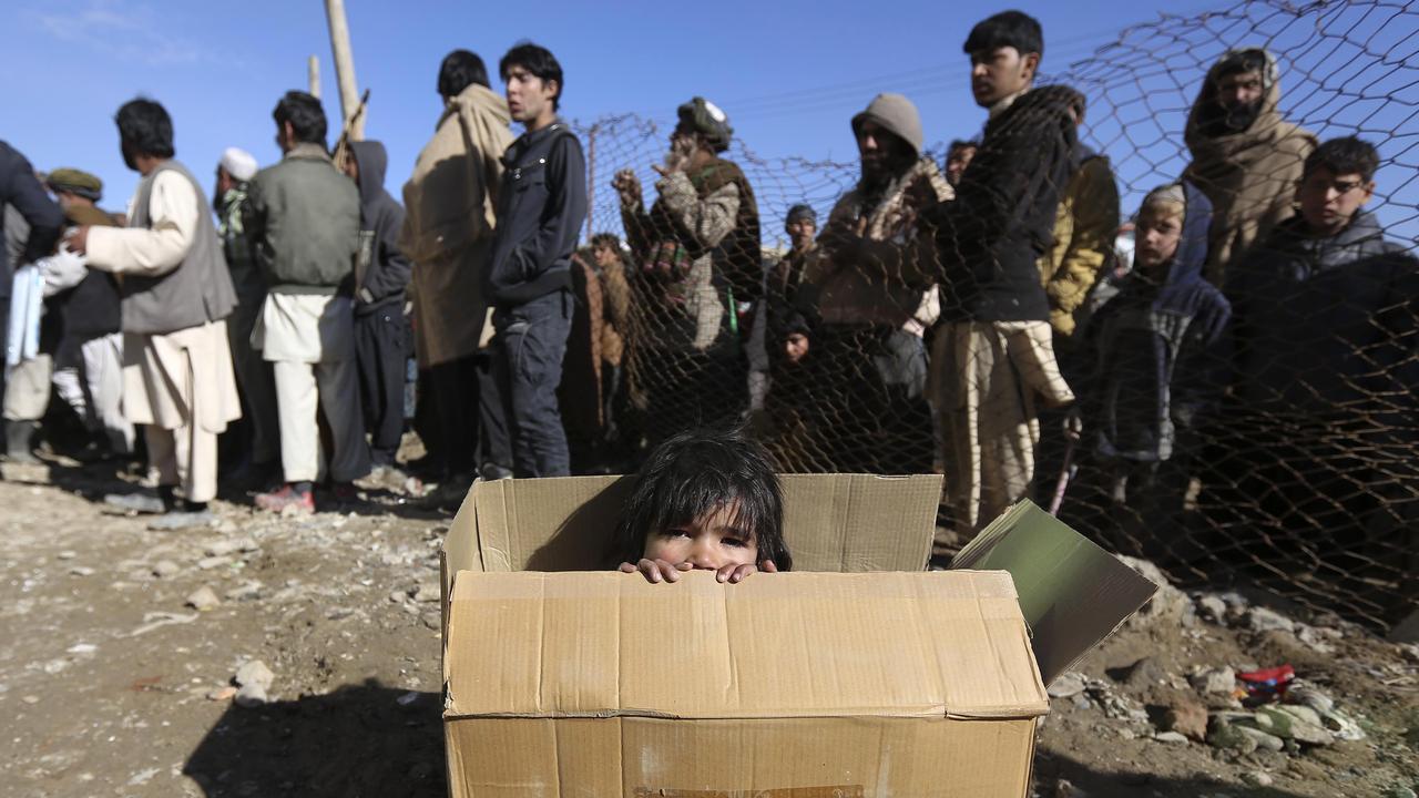 An internally displaced Afghan girl sits inside a box as she waits for the distribution of winter assistance in Kabul December 23, 2012. The United Nations High Commissioner for Refugees (UNHCR) began a winter assistance programme for returnees from Pakistan and Iran, internally displaced persons and others who are at risk in the cold weather. REUTERS/Omar Sobhani (AFGHANISTAN - Tags: SOCIETY ENVIRONMENT) [REUTERS - Omar Sobhani]