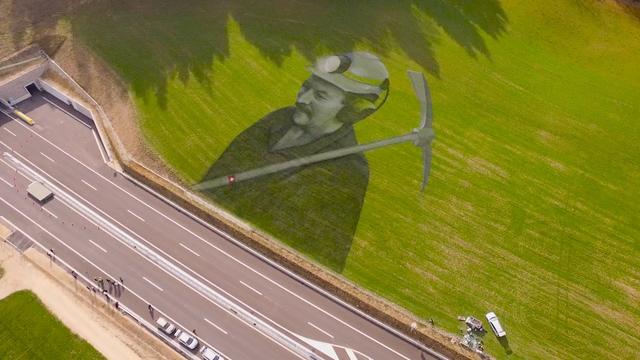 La fresque géante en hommage aux travailleurs de la Transjurane devrait rester visible au bord de l'A16 près de Bévilard pendant trois à quatre semaines. [RTS]