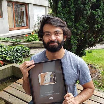 Raj, auteur de la chaîne Autodisciple, avec son trophée YouTube. [RTS - David Christoffel]