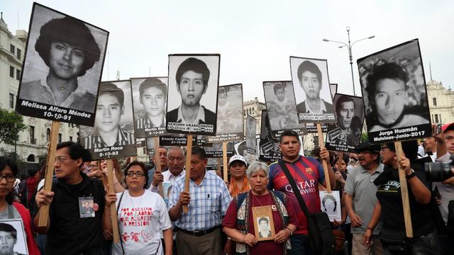 Des proches de victimes du gouvernement d'Alberto Fujimori brandissant les portrait des disparus. [Ernesto Arias]