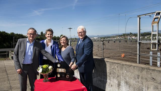 De gauche à droite, Nicolas Perrin, chef de la division CFF Cargo, Anna Barbara Remund, sous-directrice et cheffe de la division Infrastructure de l'Office fédéral des transports, Nuria Gorrite, conseillère d'Etat vaudoise, et Luc Barthassat, son homologue genevois, posent pendant l'acte symbolique devant la gare de triage de Denges (VD). [Keystone - Jean-Cristophe Bott]