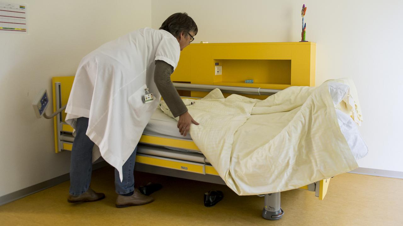 Une infirmière prépare le lit d'un patient à l'Hôpital psychiatrique de Prangins (VD). [Keystone - Jean-Christophe Bott]