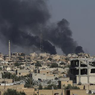 De la fumée noire au-dessus de Raqa en Syrie. [AP/Keystone - Hussein Malla]