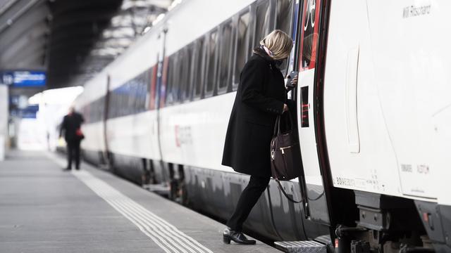 Une femme monte dans un train à la gare de Zurich. [Keystone - Ennio Leanza]