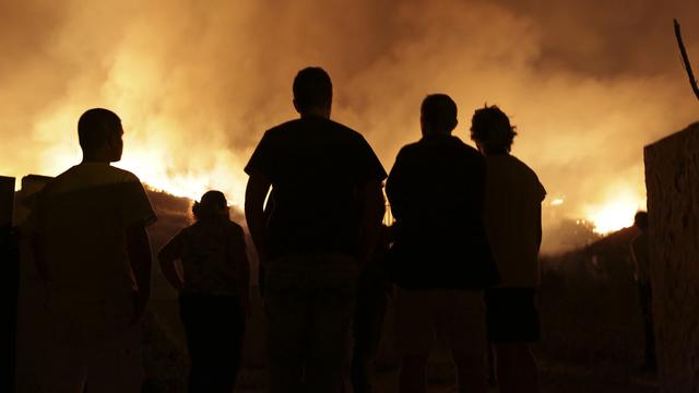 Des locaux regardent les incendies près d'Obidos au Portugal. [AP/Keystone - Armando Franca]