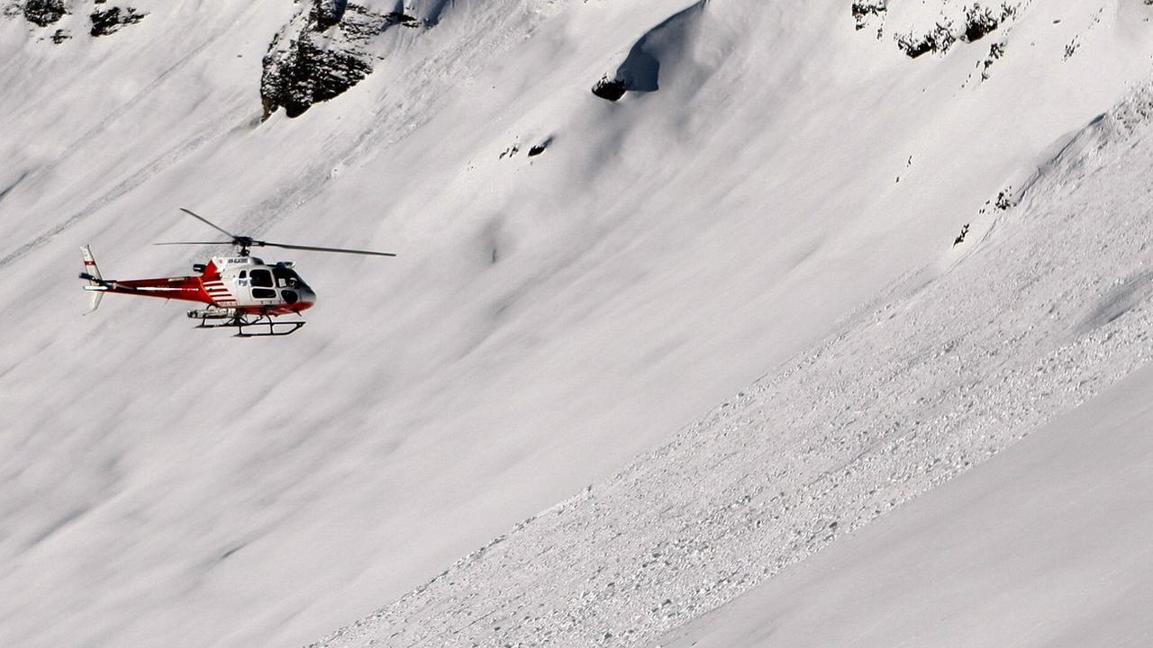 Des secouristes sondent la neige à la suite de l'avalanche causée par les trois skieurs à Anzère, en 2009. [Keystone - Jean-Christophe Bott]