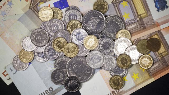 Pièces de monnaie suisses sur des billets d'euros. [Keystone - Gaetan Bally]