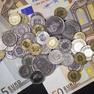 Pièces de monnaie suisses sur des billets d'euros. [Keystone - Gaetan Bally]