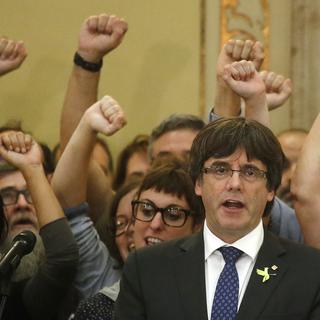 Le président du gouvernement catalan Carles Puigdemont chante l'hymne régional après le vote du Parlement sur l'indépendance. [Keystone - Manu Fernandez]