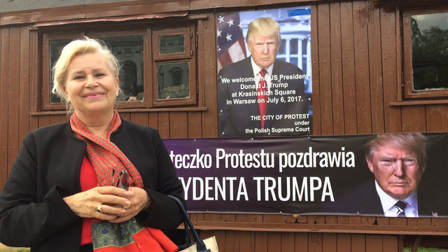 Une femme pro-Trump, qui pose devant des affiches annonçant la visite de Donal Trump en Pologne le 6 juillet 2017. [RTS - Cédric Guigon]