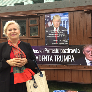 Une femme pro-Trump, qui pose devant des affiches annonçant la visite de Donal Trump en Pologne le 6 juillet 2017. [RTS - Cédric Guigon]