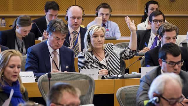 Marine Le Pen (main levée) au Parlement européen à Bruxelles en 2015. [AP Photo/Geert Vanden Wijngaert]