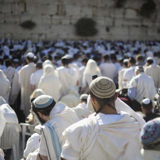 Des hommes rassemblés devant le Mur des lamentations à Jérusalem lors de la célébration d'un rite religieux. [Keystone - Ariel Schalit]