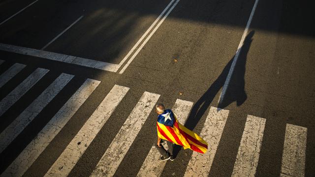Un homme portant le drapeau de la Catalogne sur ses épaules à Barcelone. [AP/Keystone - Francisco Seco]