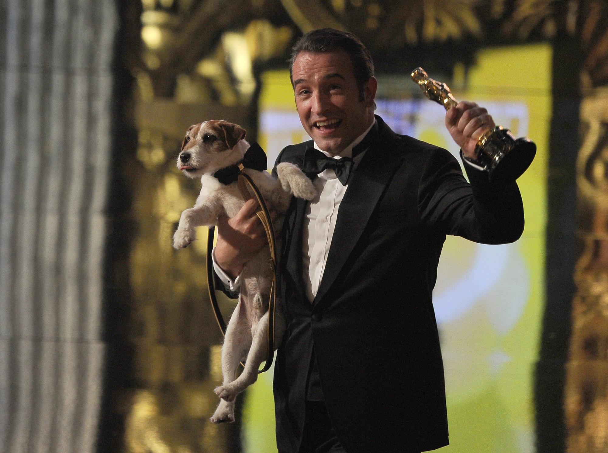 Jean Dujardin , Oscar du meilleur acteur pour le film "The Artist", avec le chien Uggie. [AFP - ROBYN BECK]