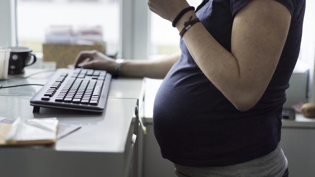 Une femme enceinte de neuf mois au travail. [Keystone - Gaëtan Bally]