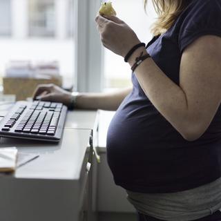 Une femme enceinte de neuf mois au travail. [Keystone - Gaëtan Bally]