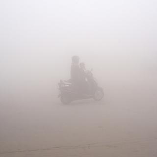 Un scooter dans le smog de New Delhi. [Keystone - AP Photo/R S Iyer]