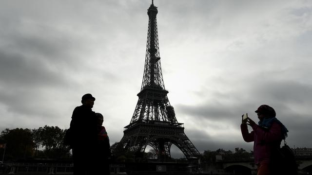 Des touristes se prennent en photo devant la Tour Eiffel. [AFP - Philippe Lopez]