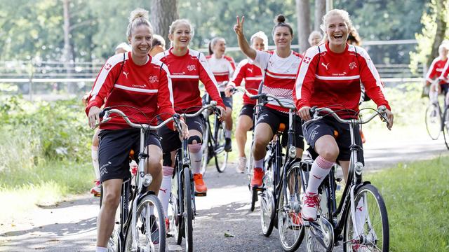 Caroline Abbé (à g.) et ses coéquipières enfourchent leur vélo pour aller à l'entraînement. [Salvatore Di Nolfi]