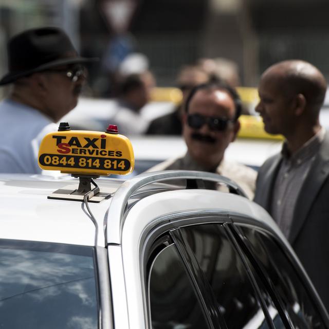 Des taxis et leurs chauffeurs à Lausanne. [Keystone - Jean-Christophe Bott]