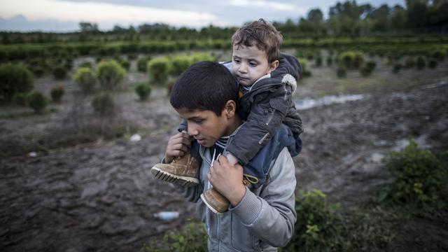 Un migrant porte son frère sur ses épaules, en Hongrie. [AFP - Arpad Kurucz]