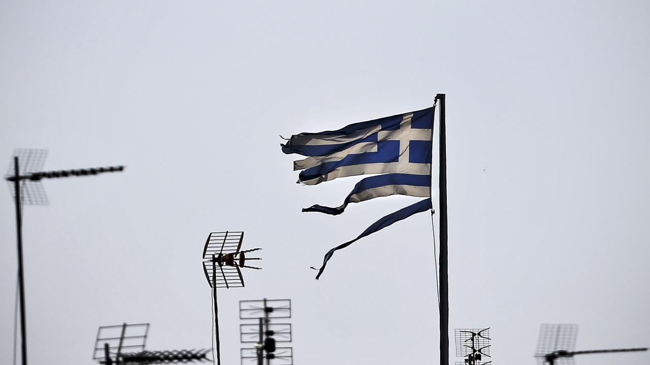 Un drapeau grec flotte au-dessus d'immeubles à Athènes. [Reuters - Alkis Konstantinidis]