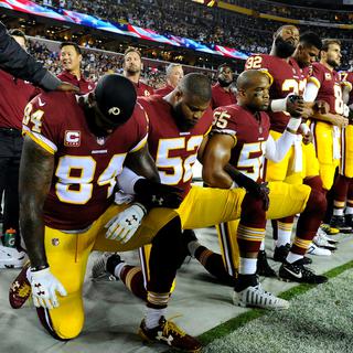 Des joueurs des Washington Redskins mettent un genou à terre lors de l'hymne national américain. [Reuters - USA Today Sports]