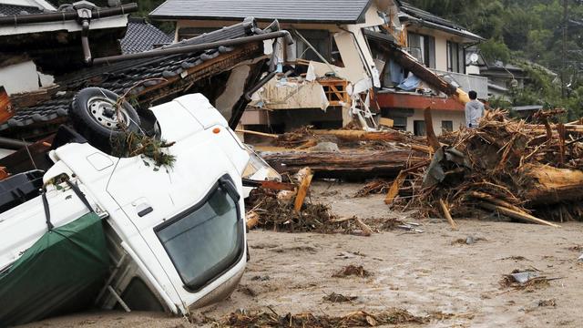 Un homme constate les dégâts le 6 juillet 2017 après le débordement de la rivière Asakura, dans la province de Fukuoka, sur l'île japonaise de Kyushu. [Keystone - Takuto Kaneko/Kyodo News via AP]