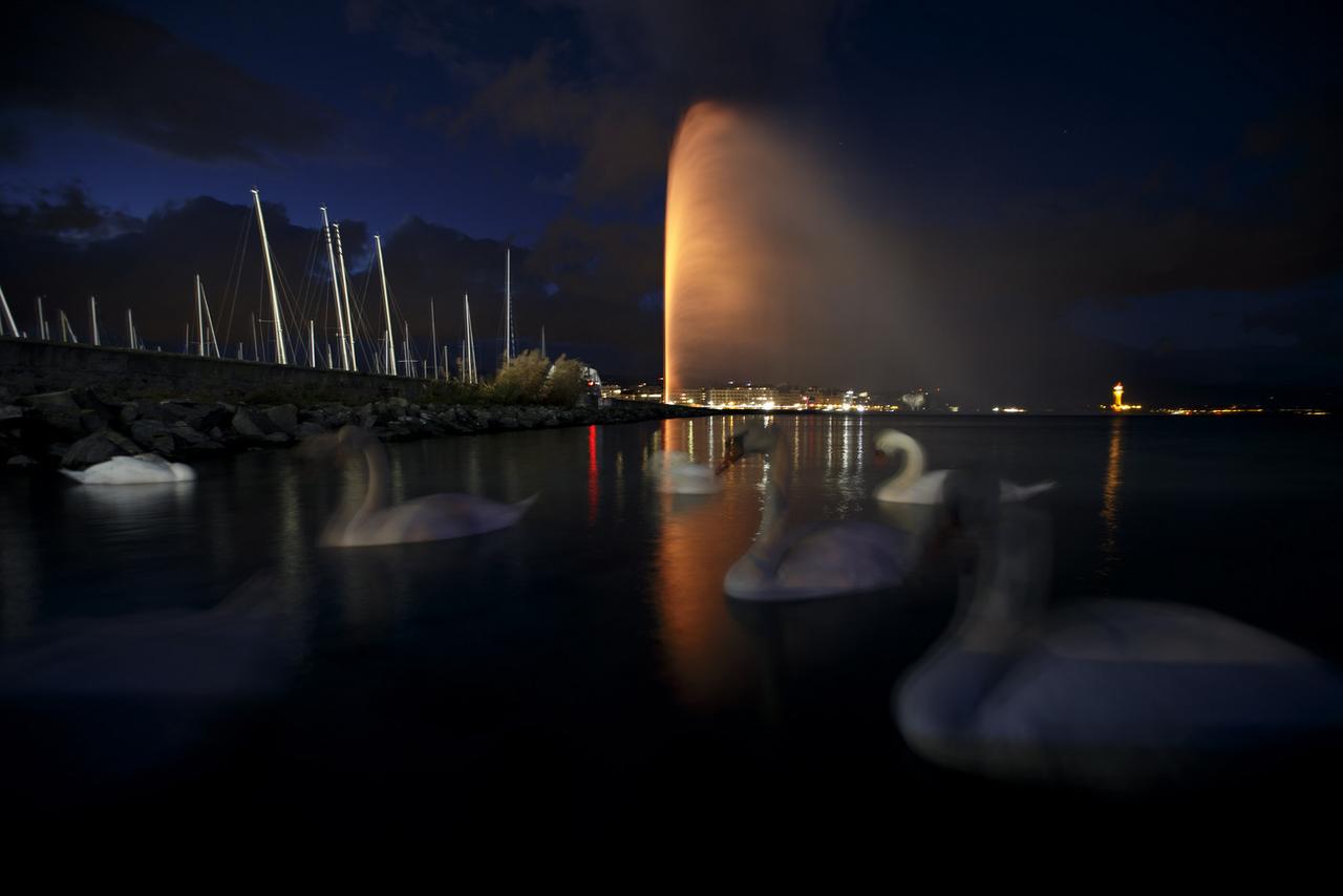 Le Jet d'eau illuminé en orange à l'occasion de la Journée internationale pour l'élimination de la violence à l'encontre des femmes. [Keystone - Salvatore Di Nolfi]